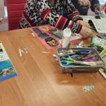 warsztaty artystyczne, uczestnicy pracują przy długim stole