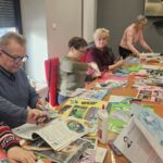warsztaty artystyczne, uczestnicy pracują przy długim stole