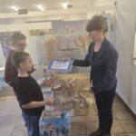 chłopcy odbierają nagrody od kobiety