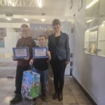 osoby stoją z dyplomami i nagrodą