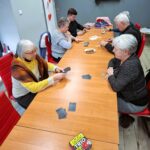 kilka osób siedzi przy stołach i gra w gry planszowe