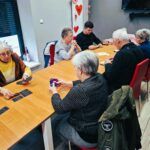 kilka osób siedzi przy stołach i gra w gry planszowe