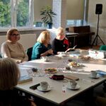 grupa kobiet siedzi przy stole