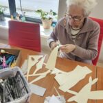 uczestniczka zajęć wycina z papieru