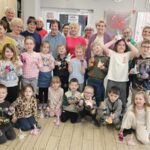 wspólne zdjęcie dzieci i Seniorów z kolorowymi zajączkami z papieru