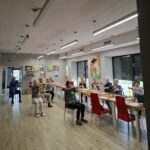 grupa seniorów wykonuje gimnastykę na krzesełkach