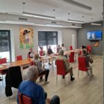 grupa seniorów wykonuje gimnastykę na krzesełkach