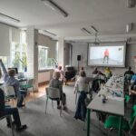 grupa seniorów ćwiczy na siedząco