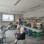 grupa seniorów ćwiczy na siedząco