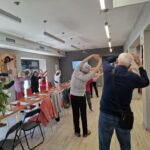 grupa seniorów wykonuje gimnastykę na stojąco