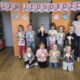 grupowe zdjęcie dzieci i pani wychowawczyni, w tle napis Dzień Jednorożca