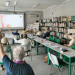 grupa seniorów ćwiczy na krzesłach