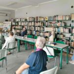 grupa seniorów ćwiczy na krzesłach