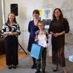 trzy kobiety stoją z dzieckiem, wręczanie nagród