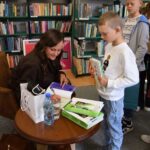 pisarka podpisuje książki, dzieci czekają w kolejce po autograf
