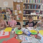 dzieci robią laurki, w tle gazetka z okazji Dnia Mamy