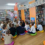 dzieci siedzą na poduszkach, słuchają bajki