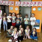 grupowe zdjęcie dzieci i pani bibliotekarki, w tle napis Dzień Jednorożca