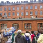 grupa ludzi przed budynkiem z cegły
