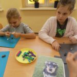 Dziewczynki lepią psy z plasteliny